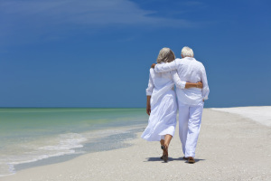 Older Couple walk on Beach - Web